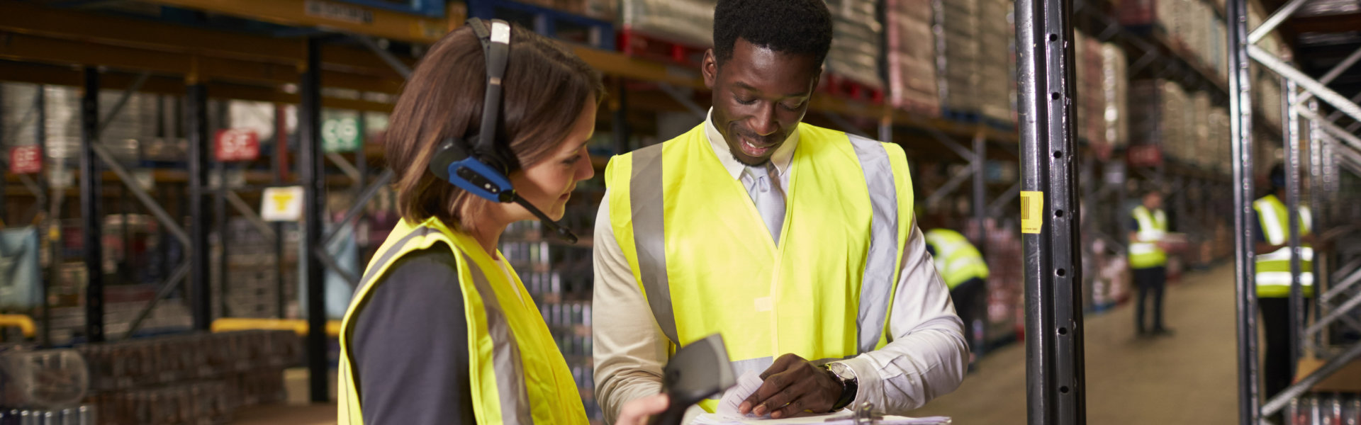 Warehouse manager talking with women using barcode reader